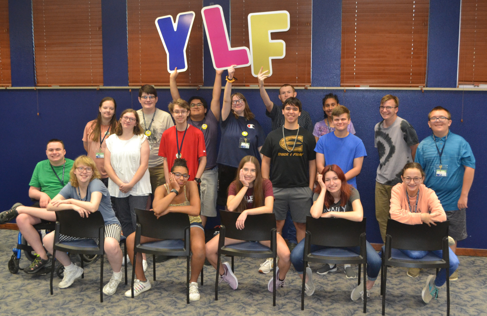 The 2023 KSYLF delegates smile while taking a group photo and holding up big YLF letters.